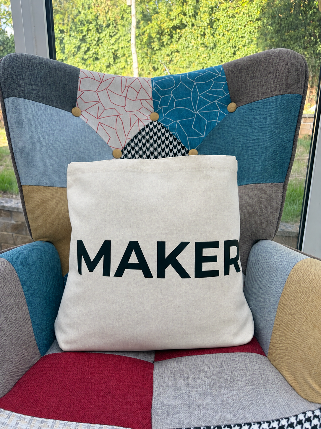 Cream canvas tote bag with black “Maker” lettering.